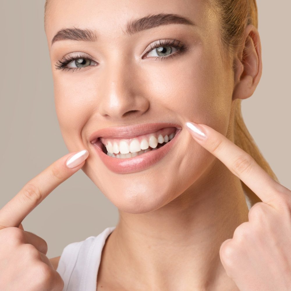 Happy Woman Pointing Fingers At Perfect Smile
